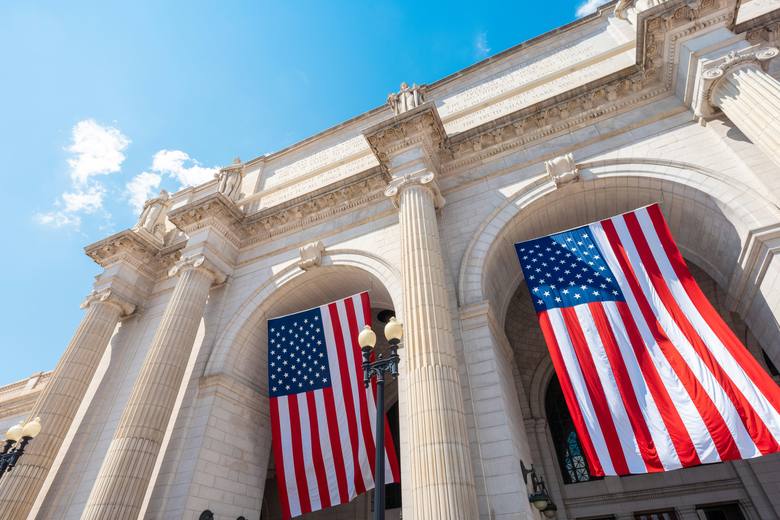 A federal building facade with United States flags